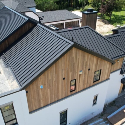 Black metal roof installation on a residential home in Birmingham, Michigan, showcasing sleek and modern design, highlighting our Michigan metal roofing expertise.