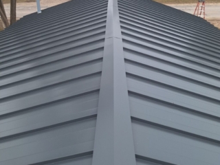 High-quality metal roof installation in Kalkaska, Michigan, utilizing Charcoal color 22ga Standing Seam Steel, demonstrating expert craftsmanship and durability for Michigan metal roofing.